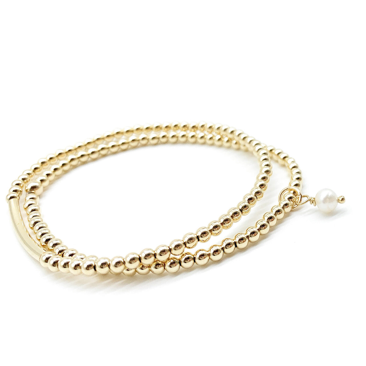 A gold beaded double-strand bracelet with a small white pearl accent, displayed on a clean white background.