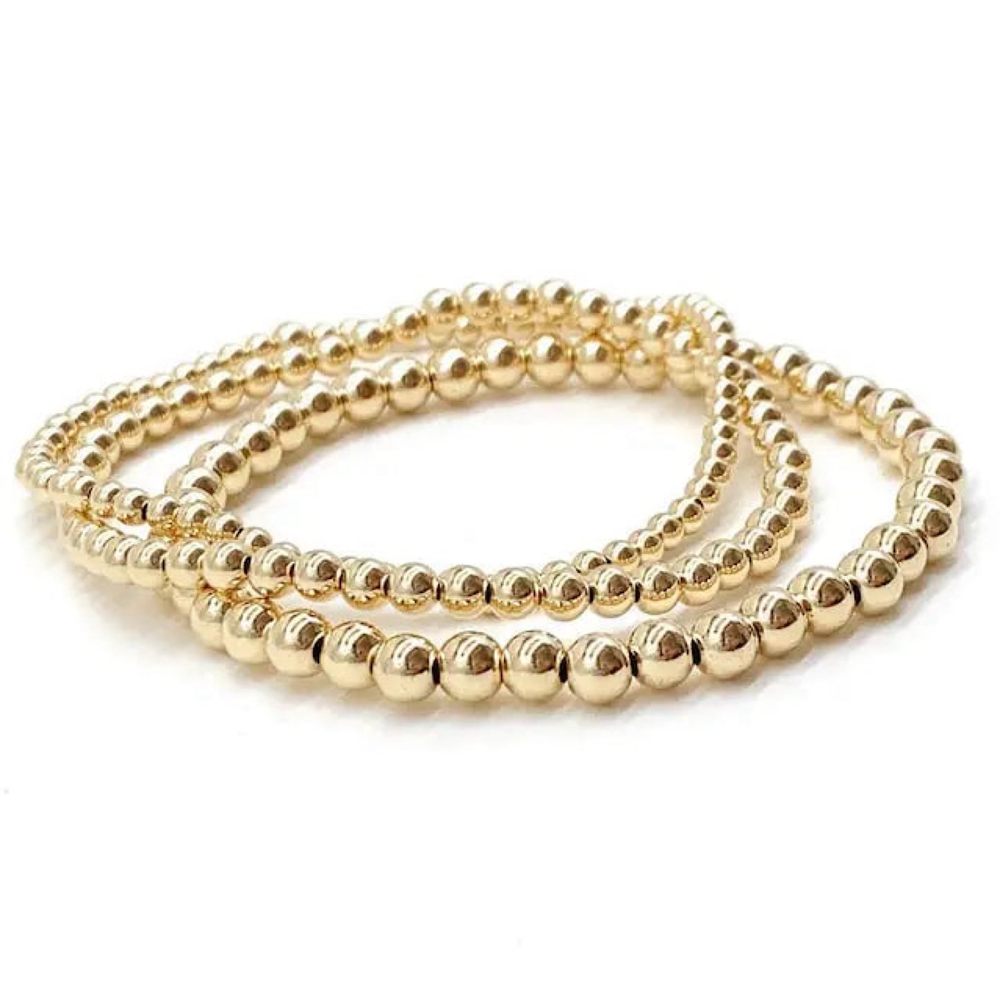Three gold beaded stretch bracelets coiled together on a white background.